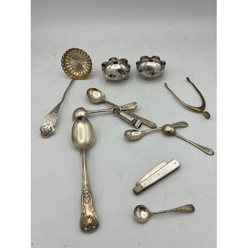 768 - A quantity of hallmarked silver to include wishbone, Birmingham 1949 James Swan & Son, Strainer, She... 