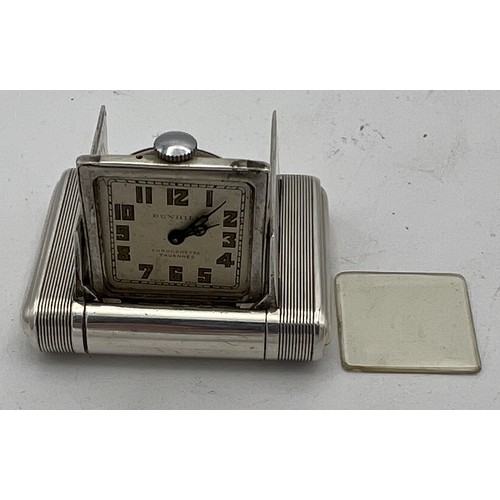 770 - An Art Deco Dunhill silver miniature travel clock, engine turned case with hinged divided doors encl... 