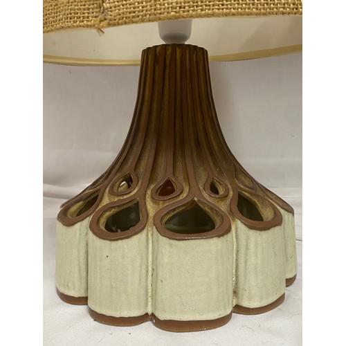 913 - A table lamp with ornate fretwork ceramic base which shines to both top and bottom. Height approx 47... 