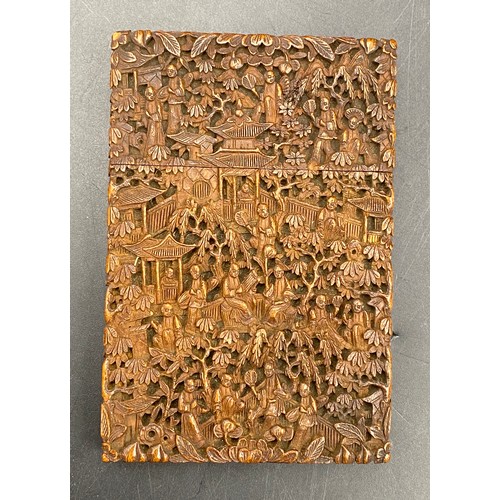 919 - A Chinese sandalwood card case, heavily carved with figures amongst pagodas and foliage, 11.5cm x 7.... 