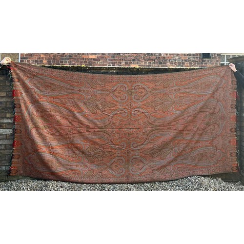 881 - A 19thC paisley patterned crinoline shawl. 335cm l x164cm w.