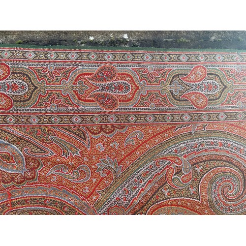 881 - A 19thC paisley patterned crinoline shawl. 335cm l x164cm w.