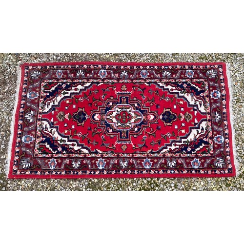 958 - A Persian rug measuring 165cm x 92cm.