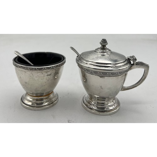 762 - A cased cruet set comprising silver mustard pot and salt and pepper, with original spoons and liners... 