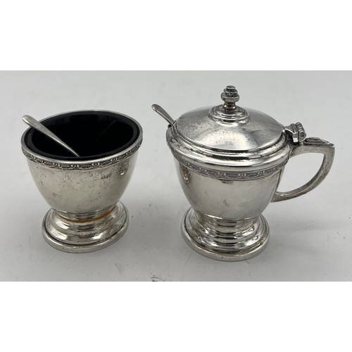 762 - A cased cruet set comprising silver mustard pot and salt and pepper, with original spoons and liners... 