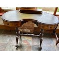 Walnut kidney shaped writing table with lidded stationary and ink section and tooled leather inset. ... 