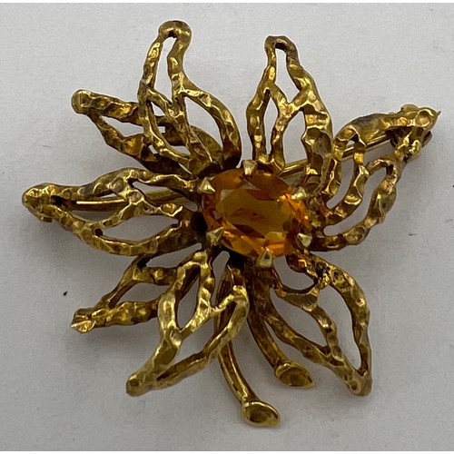 473 - A 9 carat gold brooch with central yellow stone. Weight 5.6gm. Size 4cm l.