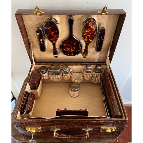 975 - A superb quality early 20thC crocodile fully fitted travelling dressing case. This comes with the or... 