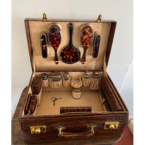 975 - A superb quality early 20thC crocodile fully fitted travelling dressing case. This comes with the or... 