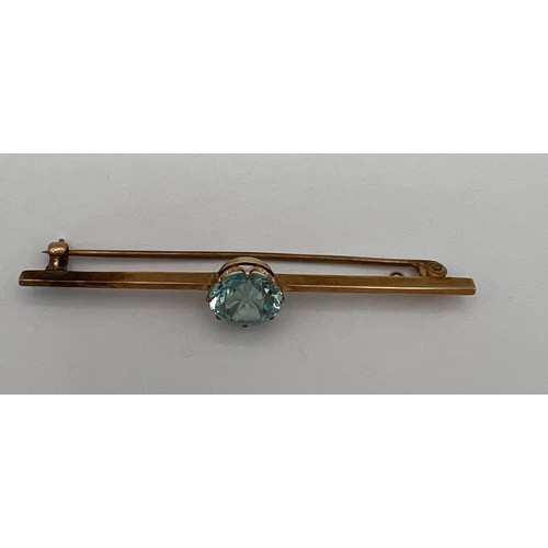 481 - Unmarked yellow metal bar brooch set with central blue stone 6cm l. Weight 4.4gm.