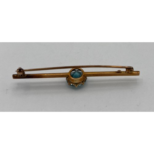 481 - Unmarked yellow metal bar brooch set with central blue stone 6cm l. Weight 4.4gm.