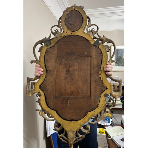 954 - A pair of 18thC ornate carved gilt wood and gesso wall mirrors with two candle sconces. 112cm h x 69... 