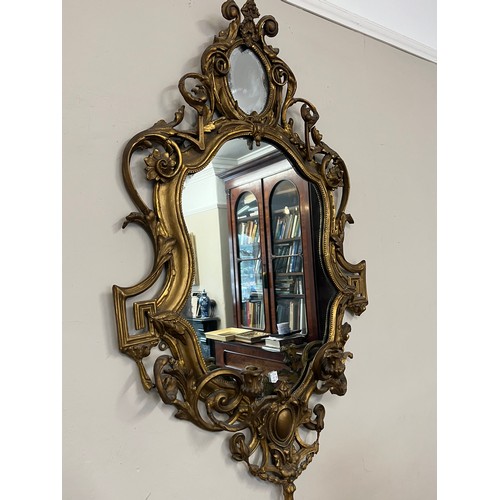 954 - A pair of 18thC ornate carved gilt wood and gesso wall mirrors with two candle sconces. 112cm h x 69... 