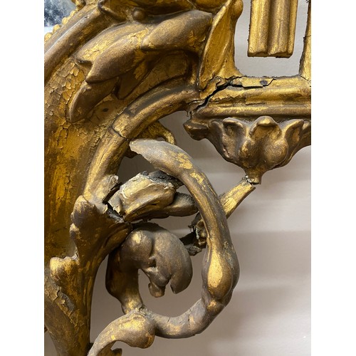 954 - A pair of 18thC ornate carved gilt wood and gesso wall mirrors with two candle sconces. 112cm h x 69... 