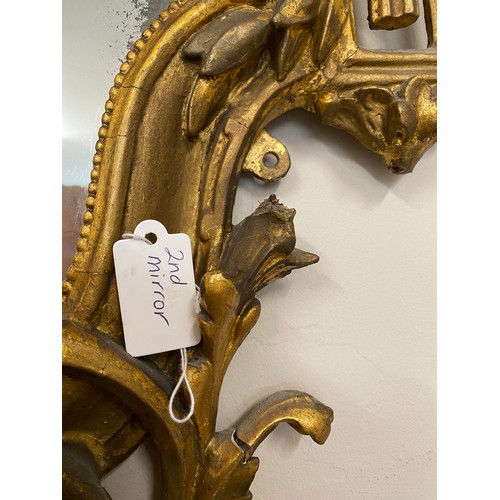 954 - A pair of 18thC ornate carved gilt wood and gesso wall mirrors with two candle sconces. 112cm h x 69... 