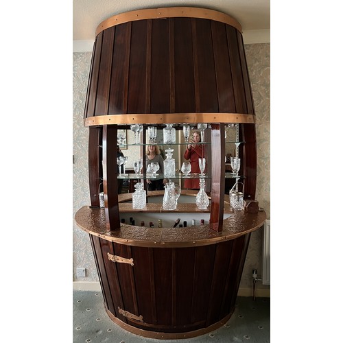 9 - A vintage mahogany and copper barrel shaped bar, mirrored to back. 240cm h x 90cm d x 171cm w.