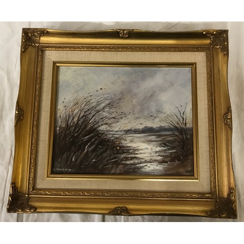 1320 - A oil on board of a windy lake scene signed lower left C. Radcliffe.