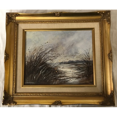 1320 - A oil on board of a windy lake scene signed lower left C. Radcliffe.