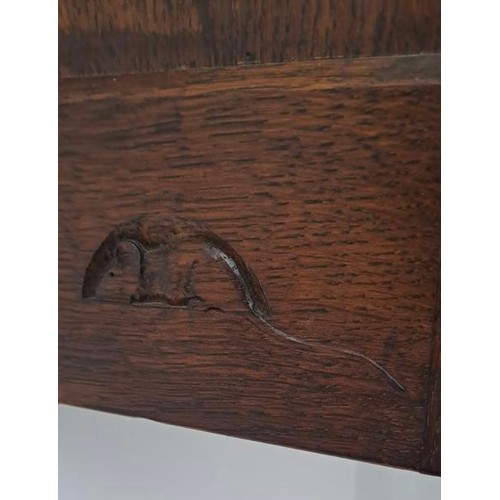 174 - An oak Robert Thompson Mouseman corner cupboard with recessed mouse, panelled door with three shelve... 