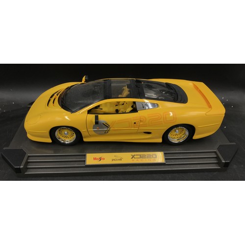 894 - A collection of toy cars to include a Maisto jaguar XJ220 racing on stand, another smaller Maisto ja... 