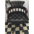 A leather deep button back mahogany framed swivel office chair.