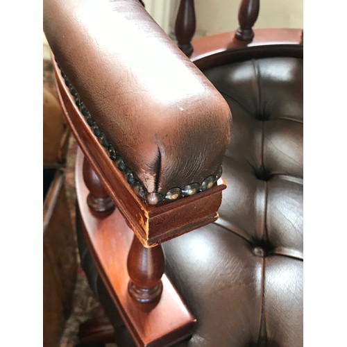 15 - A leather deep button back mahogany framed swivel office chair.