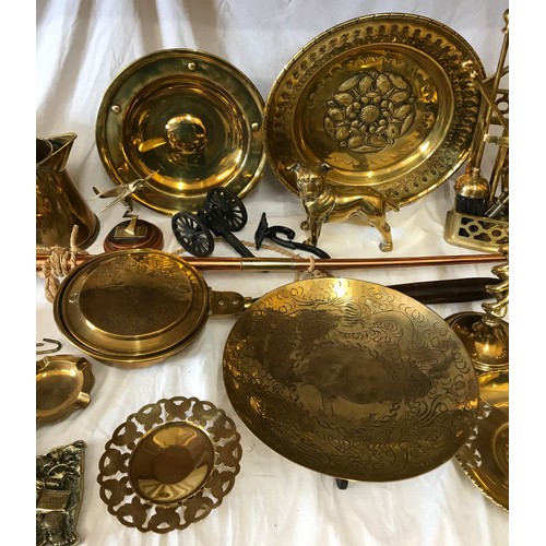 1002 - A large quantity of mainly brass items comprising: pair of candlesticks, companion set, horse brasse... 