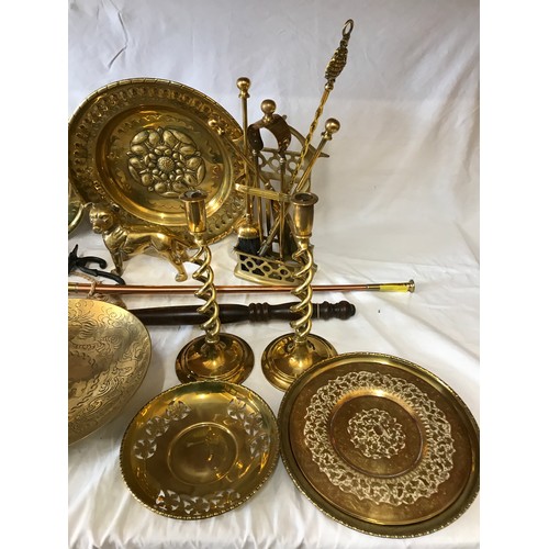 1002 - A large quantity of mainly brass items comprising: pair of candlesticks, companion set, horse brasse... 