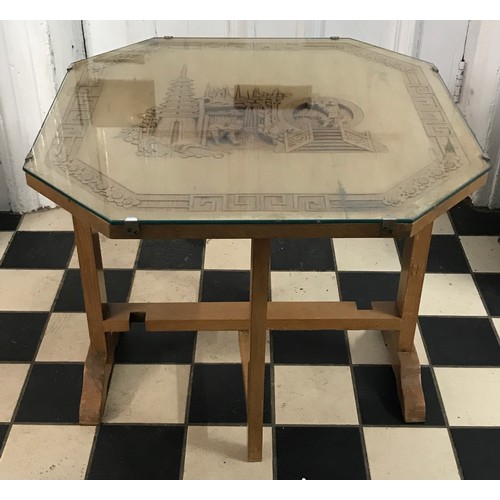 16 - An octagonal wooden carved oriental tip top table depicting men with removable glass top 53cm h x 61... 