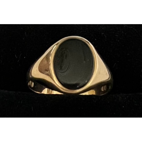 408 - A 9 carat gold ring set with oval black stone, size N, weight 1.7gm.