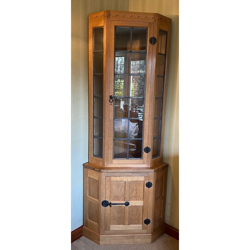 177 - Robert Thompson Mouseman corner display cupboard, the upper section with leaded glazed doors and sid... 