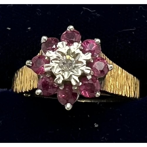 434 - An 18 carat gold cluster ring set with rubies and diamond with bark style decoration to the shank. W... 