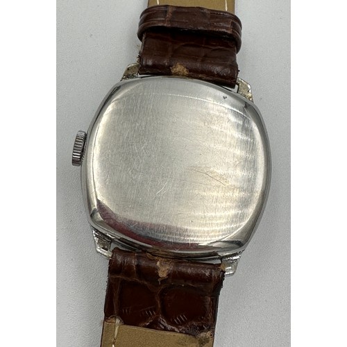 619 - A 1950's gentleman's Tudor cushion wristwatch on brown leather strap and Rolex buckle. Dennison case... 