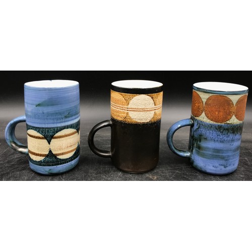 238 - A collection of three Troika mugs to include one by Avril Bennett signed A B to base, one by Marilyn... 