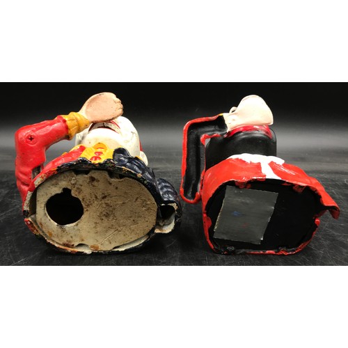 Two cast iron, hand painted, articulated ‘man eating money’ money boxes ...