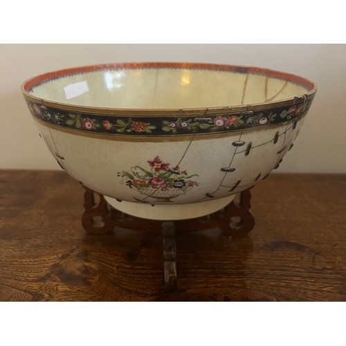 244 - An 18thC porcelain punch bowl 26cm d together with later wooden display stand. Purported to have be ... 