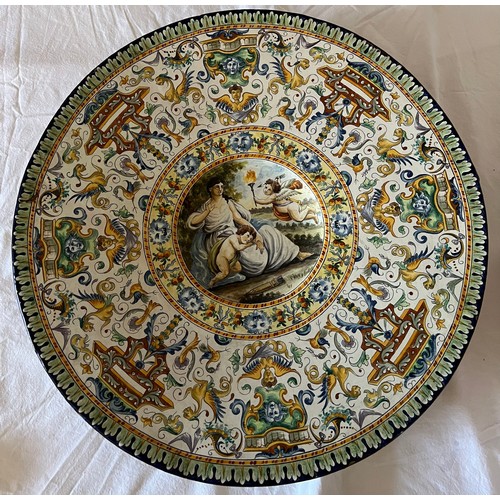 245 - A massive polychrome maiolica charger with classical scene surrounded by band of grotteschi. 60cm d.