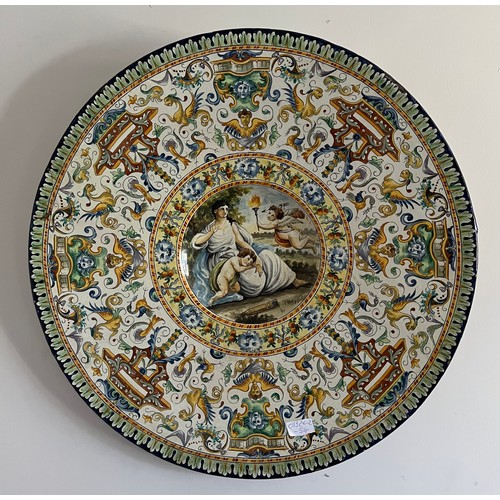 245 - A massive polychrome maiolica charger with classical scene surrounded by band of grotteschi. 60cm d.