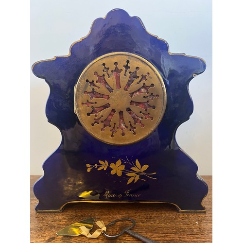 1021 - A French painted porcelain mantle clock with white enamel and floral decorated face. 27cm h.