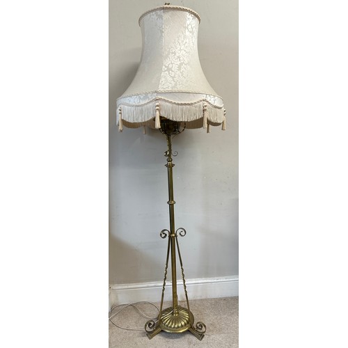 750 - A decorative scrolled brass standard lamp with shade converted from an oil lamp. 151cm h without fit... 