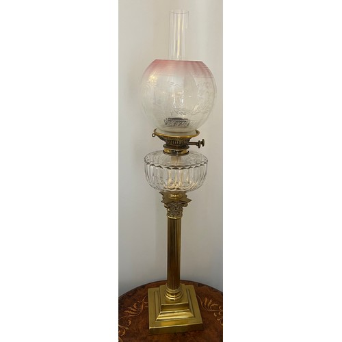 753 - A 19thC oil lamp with brass Corinthian column, clear glass reservoir and etched pink and clear glass... 