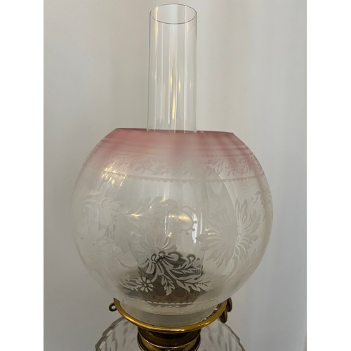 753 - A 19thC oil lamp with brass Corinthian column, clear glass reservoir and etched pink and clear glass... 