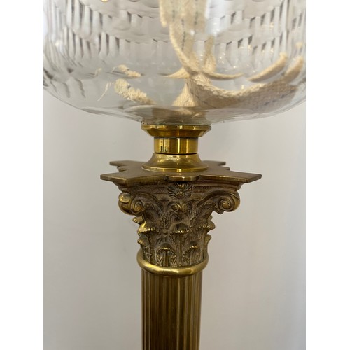 753 - A 19thC oil lamp with brass Corinthian column, clear glass reservoir and etched pink and clear glass... 