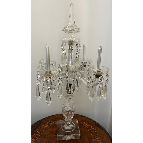 755 - A four branch glass candelabra with pendant lustre drops. 65cm h.