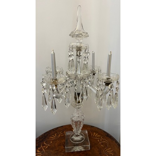 755 - A four branch glass candelabra with pendant lustre drops. 65cm h.