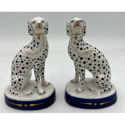 350 - A pair of Staffordshire Dalmations on blue and gilt oval bases. 13cm h.