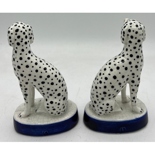 350 - A pair of Staffordshire Dalmations on blue and gilt oval bases. 13cm h.