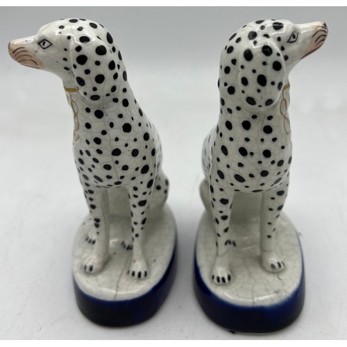 350 - A pair of Staffordshire Dalmations on blue and gilt oval bases. 13cm h.