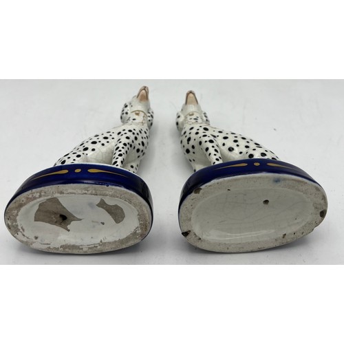 350 - A pair of Staffordshire Dalmations on blue and gilt oval bases. 13cm h.