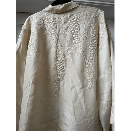 1068 - A cream vintage silk embroidered jacket with hand stitched wisteria decoration. Shoulder to hem 65cm... 